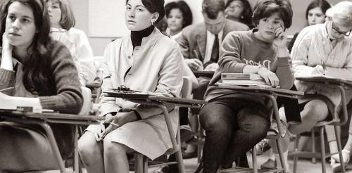 students sit in desks in a classroom